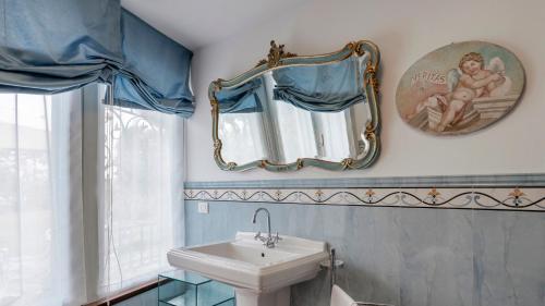 uma casa de banho com um lavatório e um espelho em VILLA EDEN 8, Emma Villas em Ispra