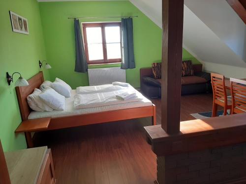 1 dormitorio con cama, sofá y ventana en Penzion Planicka en Černá v Pošumaví
