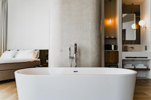 Habitación con baño con bañera blanca. en Hotel Pontsteiger en Ámsterdam