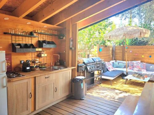 a kitchen and a living room in a house at Petit chalet " L' Oiseau de Paradis " in Fréjus