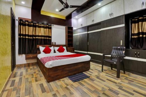 a bedroom with a bed and a chair in it at Seshadri Homestay in Tirupati