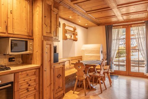 a kitchen with a table and chairs in a room at Casa Lacedel 2, on ski slopes in Cortina dʼAmpezzo