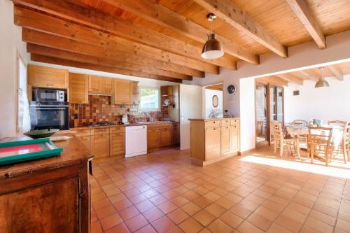 une grande cuisine avec des placards en bois et une table dans l'établissement Grande maison pour 7 à 400m de la plage, à Sainte-Marie de Ré