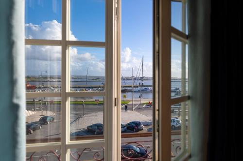 a window looking out at a marina with boats at Dona Maria Hotel in Figueira da Foz