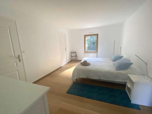- une chambre blanche avec un lit et un tapis bleu dans l'établissement Maison pour grande famille avec jardin, terrasse, proche Golf et Port à La Forêt-Fouesnant - FR-1-481-149, à La Forêt-Fouesnant