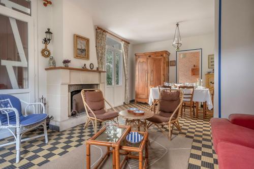 - un salon avec une cheminée, une table et des chaises dans l'établissement Maison à 350m de la plage pour 6 à St Brevin, à Saint-Brévin-les-Pins