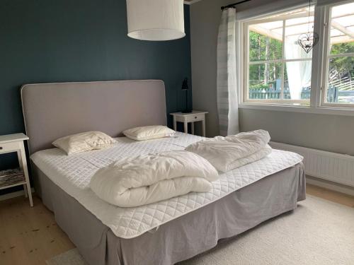 een bed met witte lakens en kussens in een slaapkamer bij Tofta Beach house in Tofta