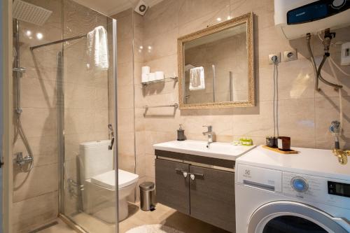 a bathroom with a shower sink and a washing machine at Stunning 2Br Apt at the Brim of the Bosphorus in Istanbul