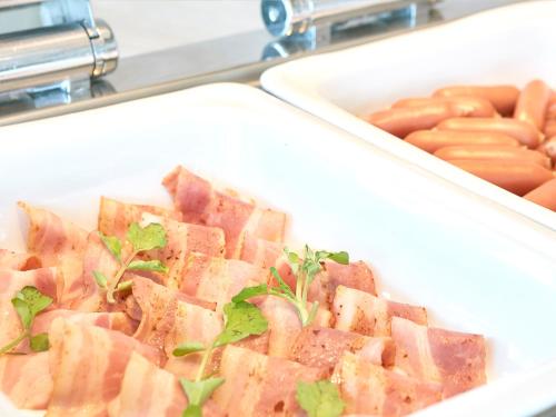 a white tray with ham and hot dogs in it at Hotel Seagull Tenpozan Osaka in Osaka