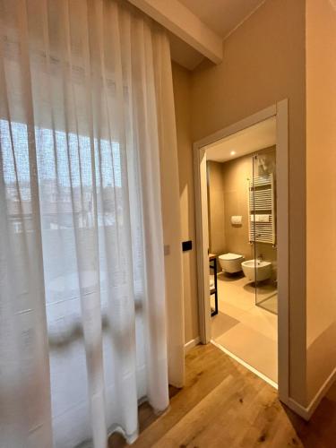 a bathroom with a toilet and a window at Hotel America in Trento