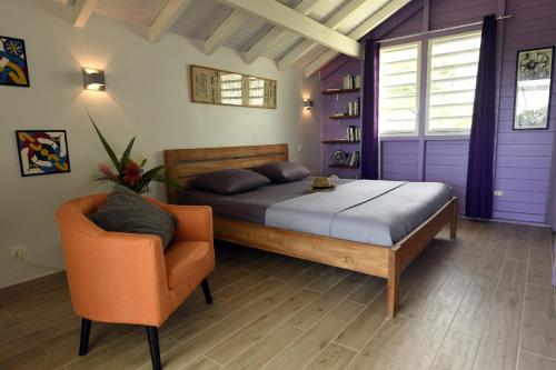 a bedroom with a bed and a chair at VILLA CAZARAMEL in Le Gosier