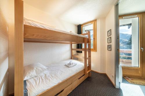 une chambre avec deux lits superposés et une fenêtre dans l'établissement Le Cap Neige - IMMODREAMS - Avoriaz, à Avoriaz