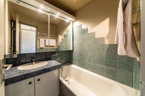 une salle de bain avec un lavabo et une baignoire dans l'établissement Le Cap Neige - IMMODREAMS - Avoriaz, à Avoriaz