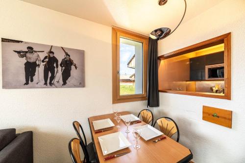 d'une salle à manger avec une table, des chaises et une fenêtre. dans l'établissement Le Cap Neige - IMMODREAMS - Avoriaz, à Avoriaz