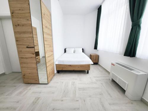 a small bedroom with a bed and a bath tub at Hotel Balon in Velika Kladuša