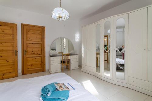 um quarto branco com uma cama e uma sala de vestir em Cotswold Sea Apart with 3 bdr at Qawra - Happy Rentals em St. Paul's Bay