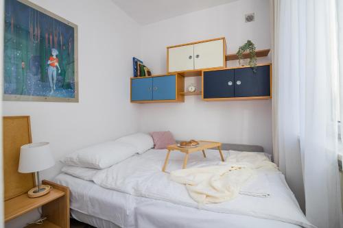 Un dormitorio con una cama con una mesa. en ShortStayPoland Plac Dąbrowskiego B140 en Varsovia