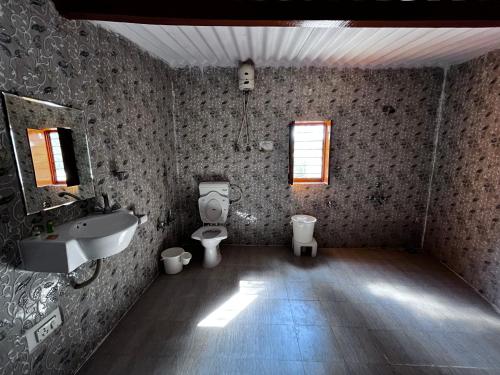 a bathroom with two toilets and a sink at Sharad Baug homestay in Bhuj
