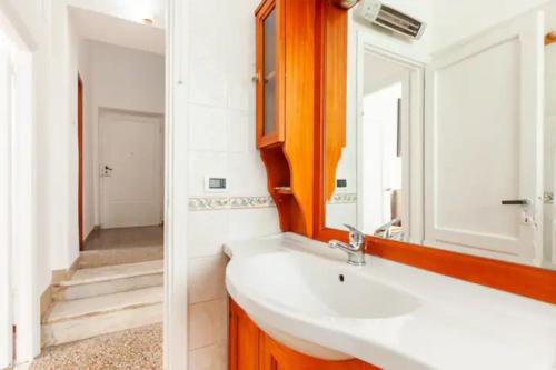 a bathroom with a sink and a mirror at Felici’s apartment agli scavi di Ostia Antica in Ostia Antica