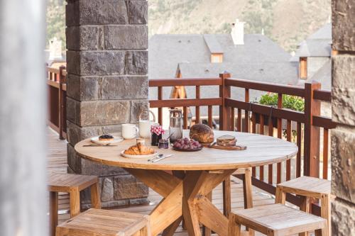 a wooden table on a balcony with food on it at Les Hauts de Saint-Lary in Saint-Lary-Soulan
