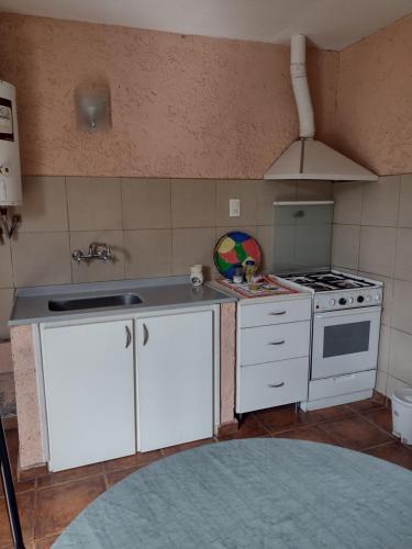 a kitchen with white cabinets and a stove top oven at Maipú soñado in Maipú