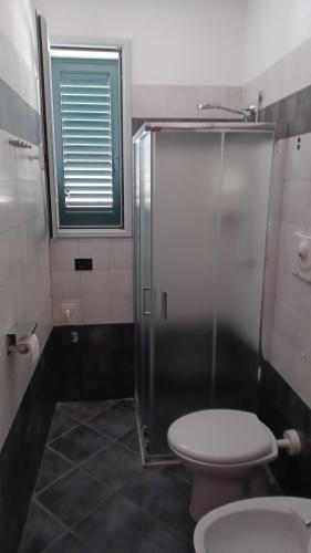 サンタ・チェザーレア・テルメにあるResidence Dario-Porto Miggianoのトイレとガラスのシャワー付きのバスルーム