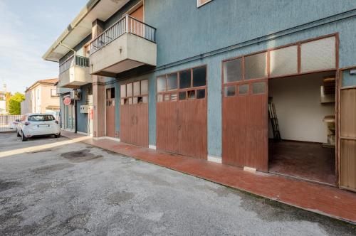 an empty parking lot next to a building with wooden doors at Zagar House-Venice Airport Close-by Apt W Parking in Campalto
