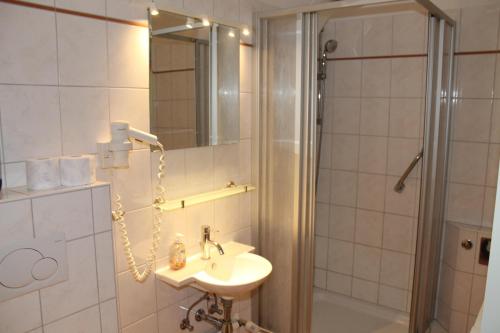 ein Bad mit einem Waschbecken und einer Dusche in der Unterkunft Großzügige Ferienwohnung E328 an der Ostsee in Brasilien
