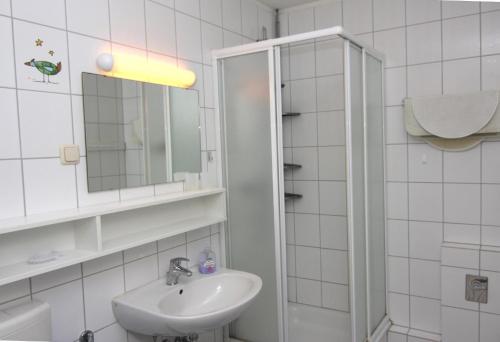 a white bathroom with a sink and a mirror at Ferienwohnung L217 für 2-4 Personen an der Ostsee in Brasilien