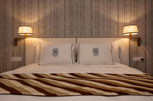 a bedroom with a large bed with two lamps at Dona Maria Hotel in Figueira da Foz