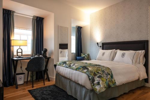 a hotel room with a bed and a desk at Dona Maria Hotel in Figueira da Foz