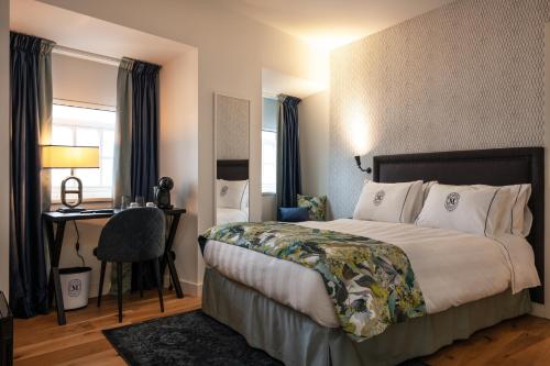 ein Hotelzimmer mit einem Bett und einem Schreibtisch in der Unterkunft Dona Maria Hotel in Figueira da Foz