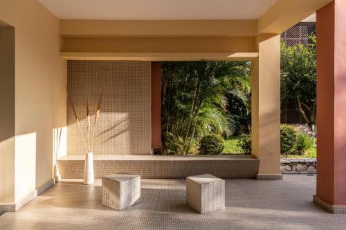 a lobby with a large window and stools at Apostolata Island Resort and Spa in Skala Kefalonias