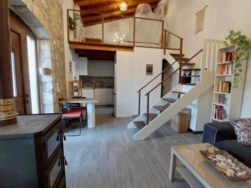 a living room with a spiral staircase in a loft at Cueva Atlantis in Stamnoí