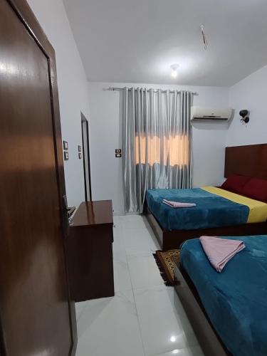 a hotel room with two beds and a window at Jamaica Guest House in Aswan