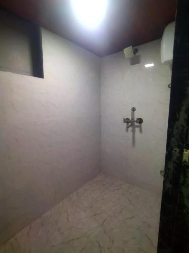 a bathroom with a shower with a wall at DC Dormitory Asalpha Metro in Mumbai