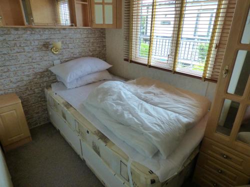 1 dormitorio con 1 cama grande con sábanas blancas en Cedar Lake 58 at Southview Leisure Park, en Skegness