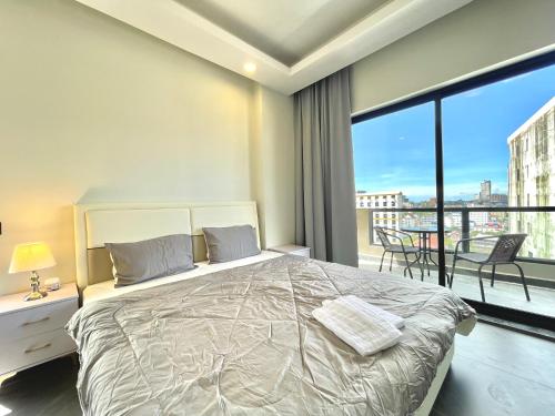 1 dormitorio con 1 cama grande y balcón en SKYVIEW Residence & Apartments Sihanoukville, en Sihanoukville