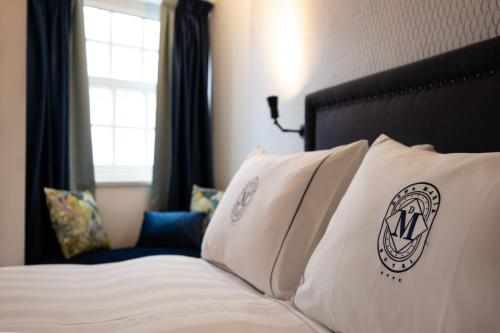 a hotel room with a bed with white pillows at Dona Maria Hotel in Figueira da Foz