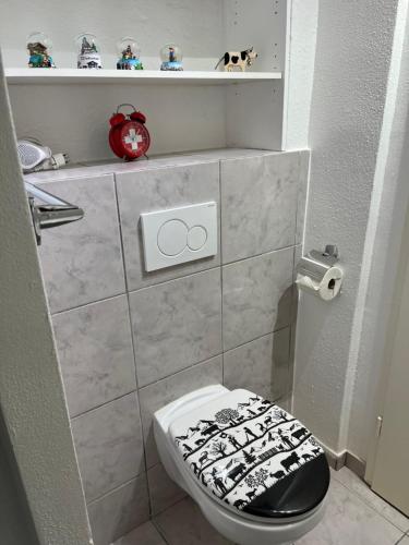 a bathroom with a toilet with a black and white lid at Le studio Suisse au cœur de Neuchâtel in Neuchâtel