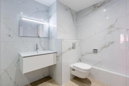 a white bathroom with a toilet and a sink at Le Wilson 13A - Joli appt refait à neuf in Strasbourg