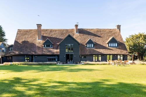 a large house with a large grass yard at Period Luxury Converted Barn Windsor/Maidenhead - Perfect for family groups in Taplow
