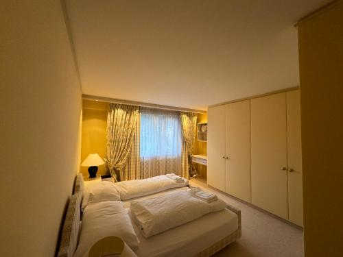 1 Schlafzimmer mit 2 Betten und einem Fenster in der Unterkunft Beautiful Apartment Davos in Davos