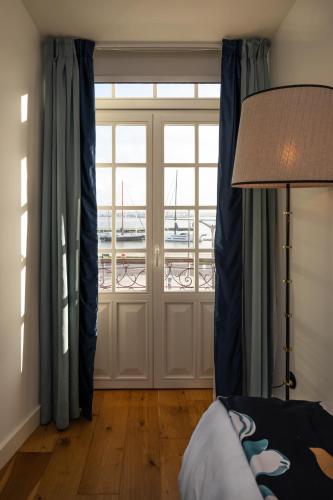 a living room with a door with a view of a marina at Dona Maria Hotel in Figueira da Foz