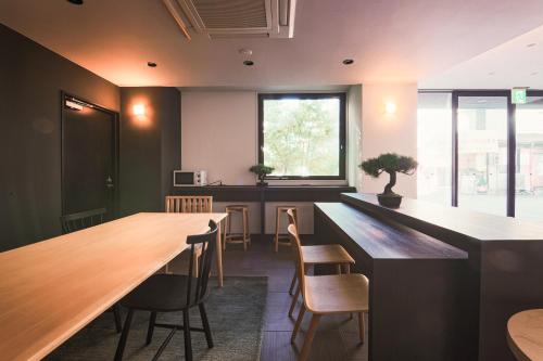 une salle à manger avec une grande table et des chaises dans l'établissement WAYFARER Matsu, à Osaka