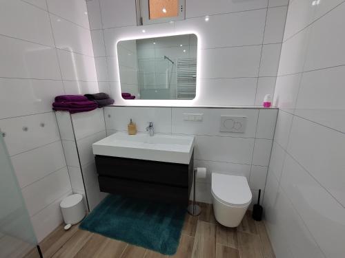 a white bathroom with a sink and a toilet at Am Boulevard in Gengenbach