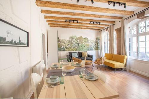 un salon avec une table et des chaises jaunes dans l'établissement La Halte Strasbourgeoise - Superbe appt près de la Petite France, à Strasbourg