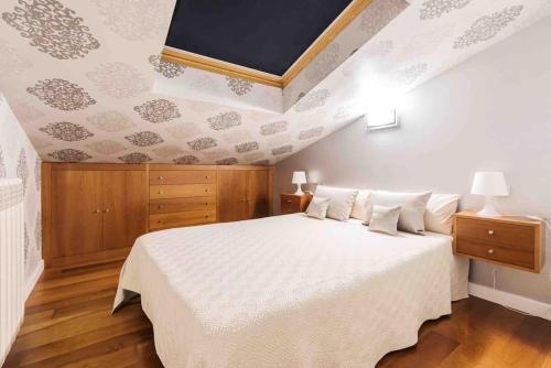 1 dormitorio con 1 cama blanca grande y techo en Apartamento Ático San Juan by Clabao, en Logroño