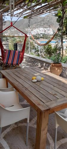 een houten tafel met 2 stoelen en een hangmat bij Aperi View in Karpathos
