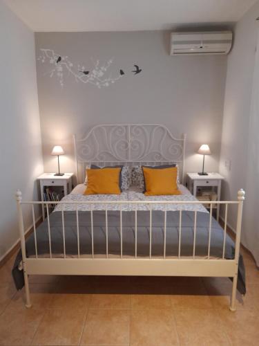een slaapkamer met een bed met 2 nachtkastjes bij Aperi View in Karpathos